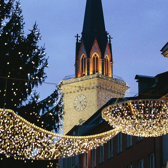 Advent in Villach mit beleuchtetem Kirchturm