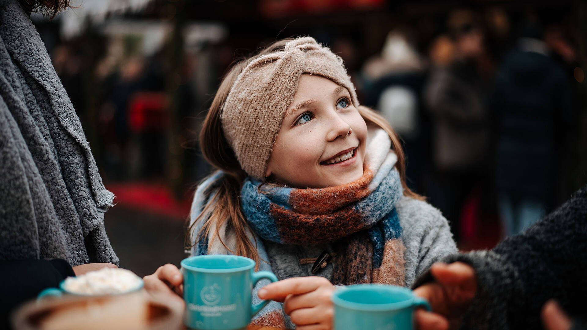 Christkindlmarkt in Klagenfurt mit der Familie, Mädchen mit Heissgetränk