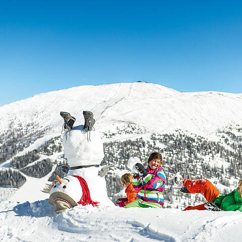 Katschberg_Kinder haben Spaß im Schnee mit Schneemann 